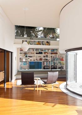A west-facing clerestory window admits late-day sunlight. Plantings screen the view of a neighboring house.