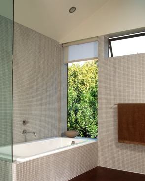 There are green views from the bathtub. Transom windows bring light into the bathroom while maintaining a sense of privacy.