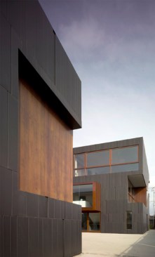The main house is located toward the rear of the lot, creating a courtyard between the two volumes and offering views of the nearby nursery