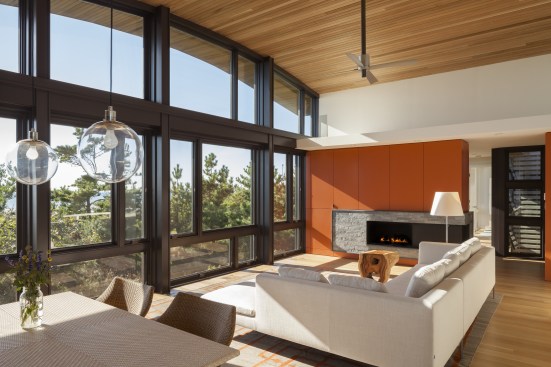The+main+living+space%e2%80%99s+primary+feature+is+its+wall+of+glass+and+priceless+views+but+at+the+north+end+is+a+wall+of+hidden+cabinetry+and+a+fireplace+for+winter+and+evening+warmth.+