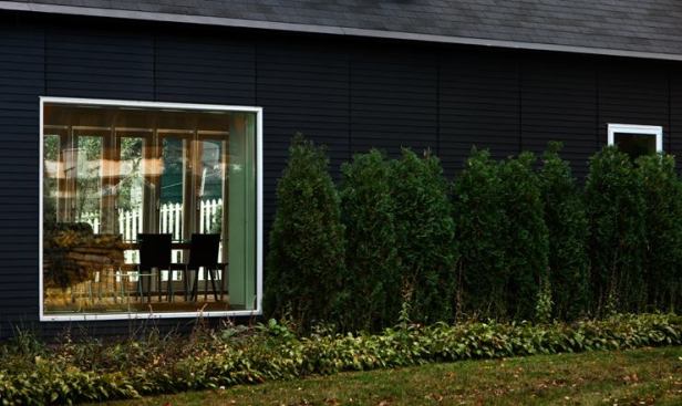 The addition's design was based on Passive House criteria for passive solar performance, glazing specifications, thermal mass, and insulation. This photo shows the outside wall of the addition that protects the courtyard; the long, narrow windows of the courtyard wall are visible through the large, square window.