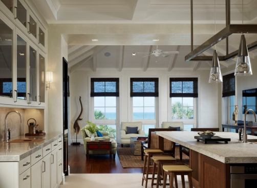 The kitchen is no longer its own domain. Designers like de Guilio are incorporating adjacent living spaces within the area.