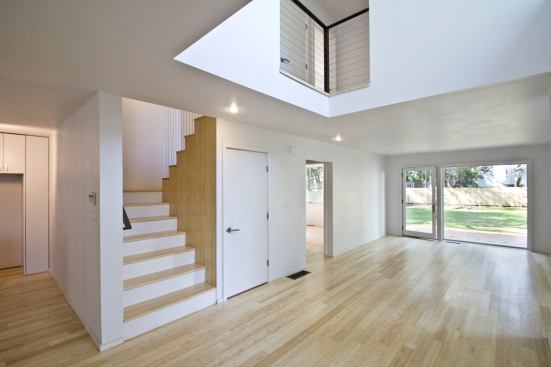 The “Chinese puzzle” configuration of the house creates two interlocking ell-shaped layouts, resulting in double-height spaces in both units.