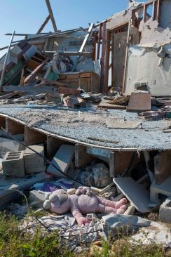 An underfloor crawl space is described as a “safe area” in tornado preparedness literature. However, the risk is still substantial for homeowners who seek refuge in any hiding place in a typical older house. Here, the block foundation has been shattered and the floor has fallen down; upstairs rooms were mostly completely destroyed. An engineered safe room or tornado shelter is far more reliable as a refuge than any part of a conventionally built wood house.