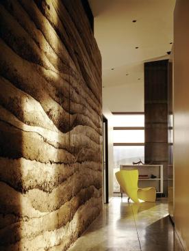 The site itself supplied the rammed earth's principal material, a sandy loam excavated only steps away. A two-inch core of rigid foam insulation provides a thermal break.