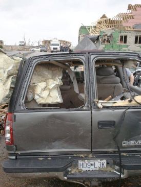 The Huddlestons’ Chevy Suburban where it came to rest on the day of the storm. Windborne debris shattered the rear windows. In the background is the ruined dentist’s office where the family sought shelter from the hail, rain, and wind.