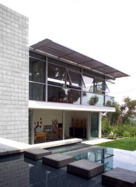 View from existing space to the spa and adjacent pool. The master bedroom cantilevers five feet, providing protection from the sun. Operable windows, overhangs, and concrete floors are key elements of passive-solar design in Southern California.