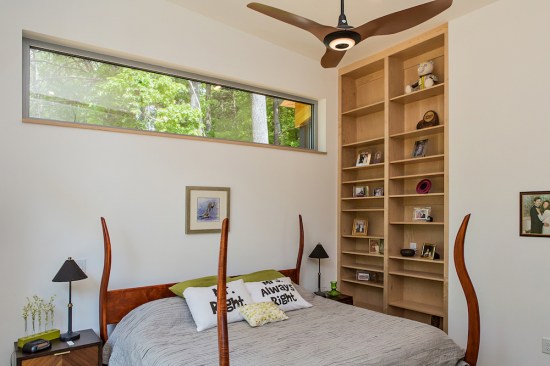 A high horizontal window leaves headboard space in the master bedroom.