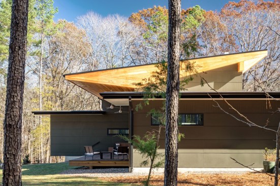 Viewed among the pines, the natural cypress on the largest roof section seems to glow in the sun.