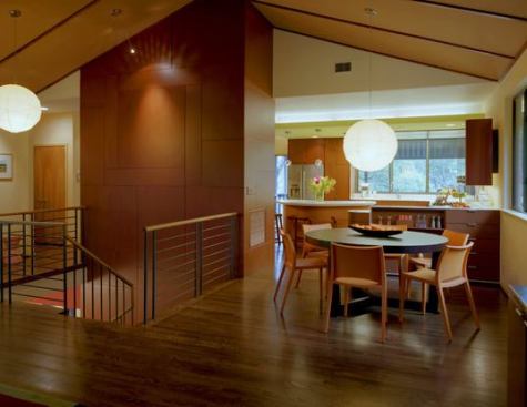 A working couple with three young boys were dissatisfied with the 1980s-style and layout of their kitchen. The new design reorganizes the circulation and provides visual connections between spaces. (Center: A separate project turned the stairs and created a vertical "core" that houses a pantry, laundry, and HVAC system.)