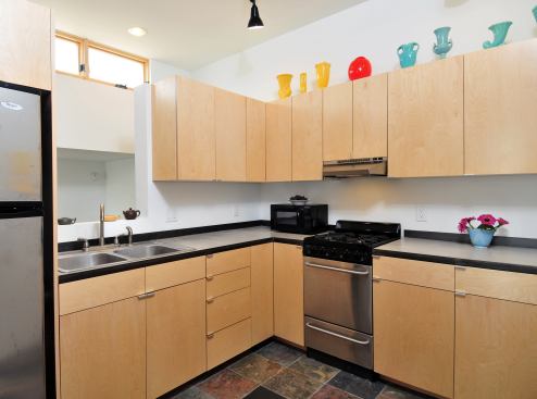 In this modest kitchen, the concrete countertops were cast on-site. The steel edge served as a form for pouring the concrete and remains as a visual accent.