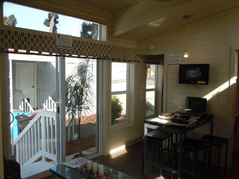 The entry features sliding glass doors, transoms, and large windows that bring light into the interior.