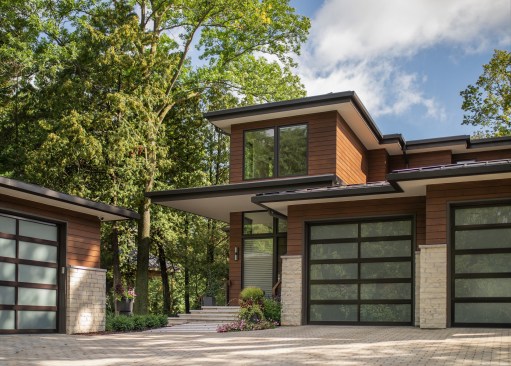 The sheltered privacy of the entry is ensconced in rising stone walls that offer a connection to the natural site. The horizontal treatments from the garage door panels and pavers to the foyer stair create guidance to the entry where gathering spaces are found that expand to the lake.