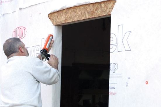 Caulk the OpeningBefore installing the window, I apply a heavy bead of elastomeric latex caulk at the jambs and the head, but I never caulk the sill flange area. 
Note: Should any moisture find its way into the rough opening, this caulk-free sill flange, coupled with the sloped sill, will provide a weep area for water to escape.
