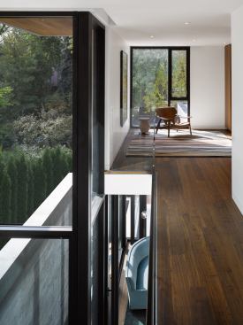 A floor cutout with a glass guardrail allows communication between the first and second floors.