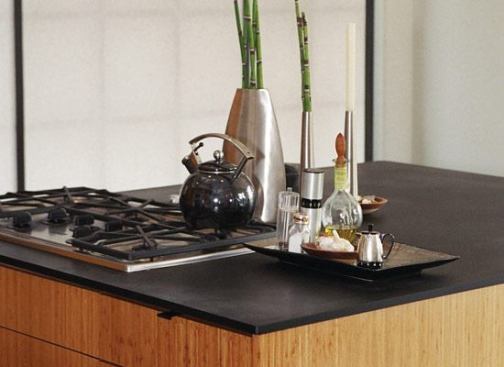 Paneltech Products PaperStone is a surfacing material made from 100% post-consumer paper, resins, and pigments. You can pay full price, or you can visit Green Countertops Direct 
www.greencountertopsdirect.com and, at discounted prices, buy panels left over from completed jobs or discontinued colors. 
www.paperstoneproducts.com.