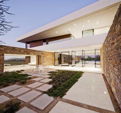 Pivoting glass doors open the house to the entry courtyard.