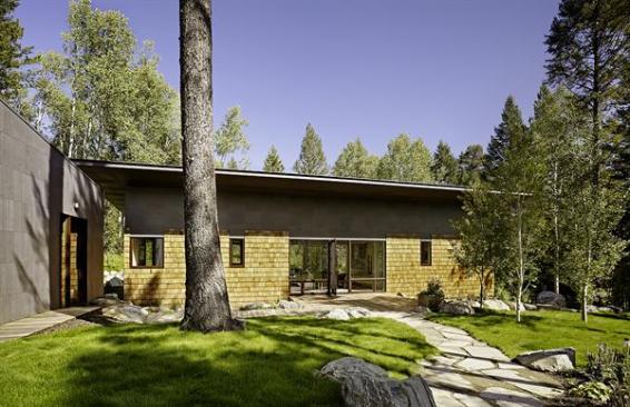 A separate garage, covered in the same fireproof bonderized steel panels that clad the upper portion of the guest house.
