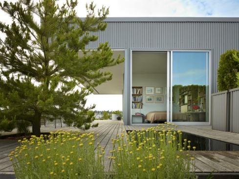 Situated atop a marina warehouse, The Miller|Hull Partnership's Sky Ranch single-family residence serves as a caretaker's unit, providing contemporary living spaces complete with a bedroom, full kitchen, built-in shelving, rooftop gardens and deck, and views of the marina.