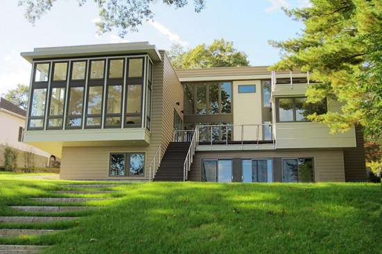 Wide+wood+steps+lead+down+from+an+elevated+courtyard+to+a+lower+terrace+with+hot+tub%2c+and+to+granite+steps+set+into+the+hill+that+lead+down+to+the+lake.+