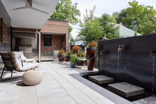 The patio includes an outdoor kitchen and custom steel fountain.