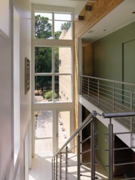 Big windows flood the double-height front hallway with sunlight.