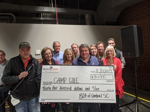 Michael and Robyn Nieri present a check to Camp Cole with members of the Building Industry Association of Central South Carolina.