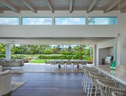 The house captures the view and provides a visual connection to the adjacent golf course. The large covered lanai creates seamless indoor-outdoor living and weather protection for the expansive pocketing glass doors.