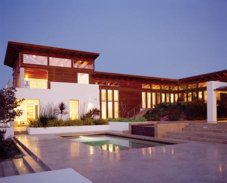 Rear terraces coalesce around a multi-part pool and an outdoor kitchen.