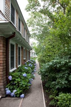 Two crushed granite paths parallel the property's long outer edges and lead to the Bay view at the rear.