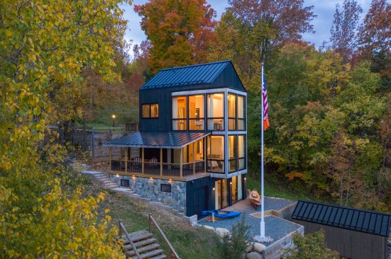 The shou sugi ban siding helps the home cohere with its exterior surroundings, while the white wood shiplap walls provide contrast and brightness inside.