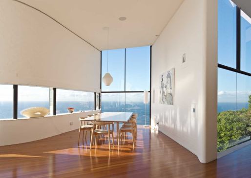 The dining room area and entry hall overlook the wild south coast and the blue waters of the Tasman Sea.