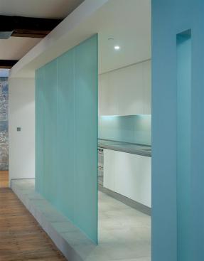 Fixed translucent-glass panels define the kitchen's edges while allowing light to filter through.