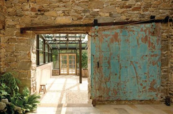 The worn blue door, found in a local warehouse, marks a service entrance between the kitchen and orangery.