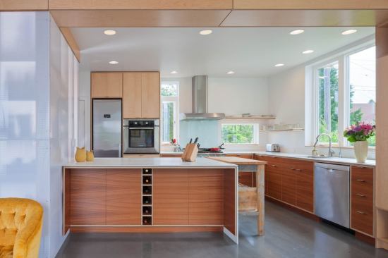 Translucent polycarbonate walls around the pantry let natural light into the enclosed space and produce playful shadows that add interest in the open kitchen/dining area.