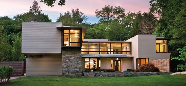 A low stone wall and cedar fence define the entry courtyard, giving this house a subtler gradient of privacy than most of its suburban neighbors.