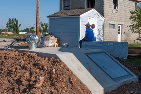 A concrete in-ground shelter outside a new building in Joplin. Buried tornado shelters offer the advantage of protection by the earth. However, they have the disadvantage that the resident needs to leave the home and risk the severe conditions outdoors in order to enter the shelter.