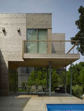 A cantilevered master bedroom forms a canopy over the rear dining terrace.