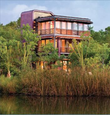 This three-story guesthouse begins its ascent 20 feet above the floodplain, where it gains a lofty perspective on the surrounding water and wetlands. The building comprises a glass box that captures panoramic views for the living spaces and an opaque copper-clad mass that contains service areas and protects the glass box from the hot western exposure.