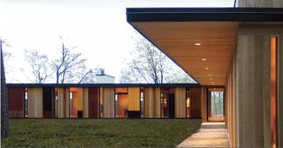 To capture the views—and light—the architects used a folding glass-door system and fixed-glass openings throughout. The definitive note, however, is sounded by the exterior, clad in untreated cedar and layered with colorful wood veneer panels applied in an organization that echoes the trees on the site.