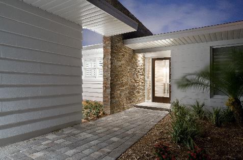 A touch of "mid-century" modern inspired by Frank Lloyd Wright was given to the breezeway with a ledgestone wall that flows from the outside through the entrance and into the kitchen.