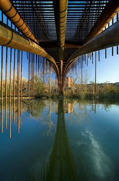 Five nested metal pipes, 5 inches in diameter and 100 feet long, span the 80-foot-wide waterway. As the uncoated metal rusts, it becomes further blended into the landscape.