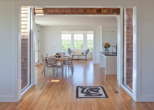 A view through from the living through the dining area to the window-lined sunroom.