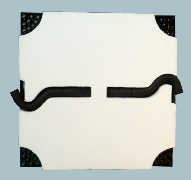 The bottom of this pedestal-mounted panel is covered with insulation. The insulation does not extend to the corners in order to support connections among pavers.