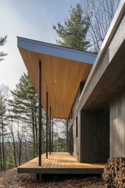 The expansive wrap-around deck floats above the ridge line and mirrors the strong angled roof.