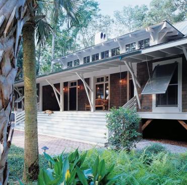 Low Country forms and West Indies details mark the exterior of both the main house and its two-bedroom guest cottage.