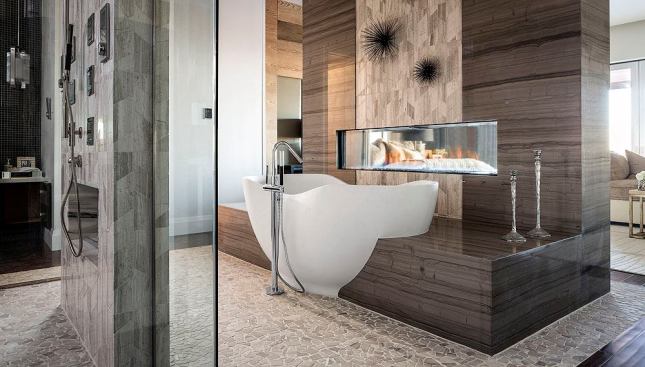 The freestanding Abrazo bathtub from Kohler creates a striking focal point with its organic oval shape. The tub is made from lithocast, a solid-surface material that looks like stone but is warm to the touch.