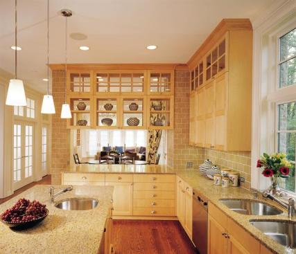 Glass upper cabinets and a wide pass-through let the kitchen flow naturally into the breakfast and family rooms. Warm-hued materials like maple and sand-colored granite ensure a bright, welcoming space.