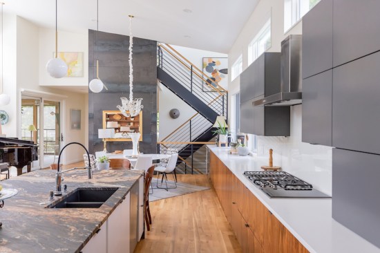Beyond the kitchen  and dining space, an open staircase provides vertical circulation (along with an elevator).