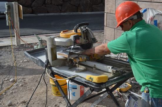 Workers cut tile.